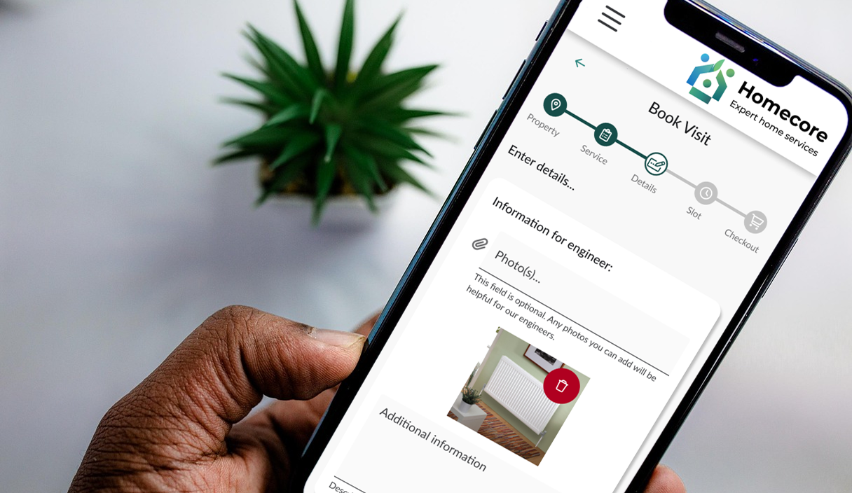 Photo of a hand holding a mobile phone, with the Homecore system on screen