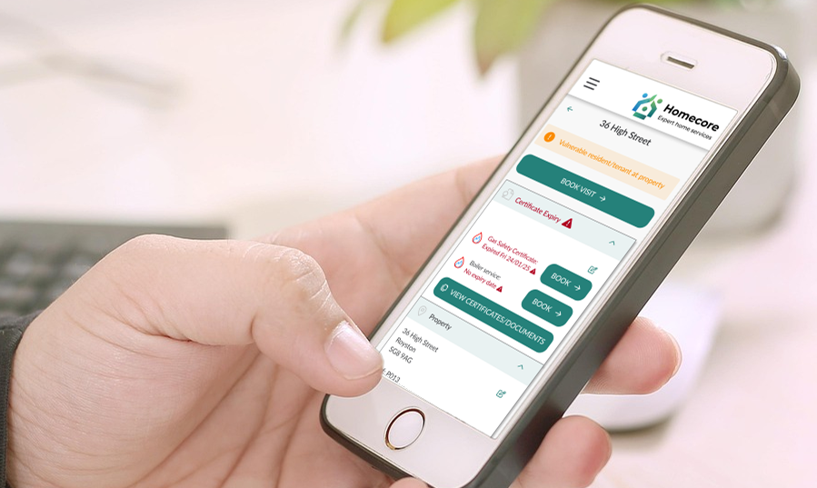 Photo of a hand holding a mobile phone, with the Homecore system on screen